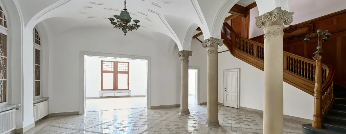Hall with columns and a wooden staircase